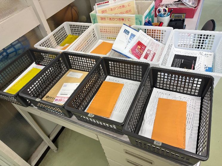 生活部の仕事。郵便物をかごに仕分けしている様子